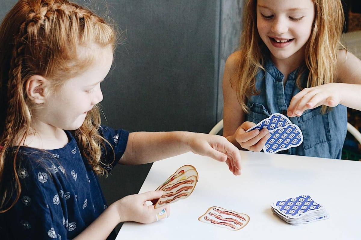 A group of girls playing cardsDescription automatically generated